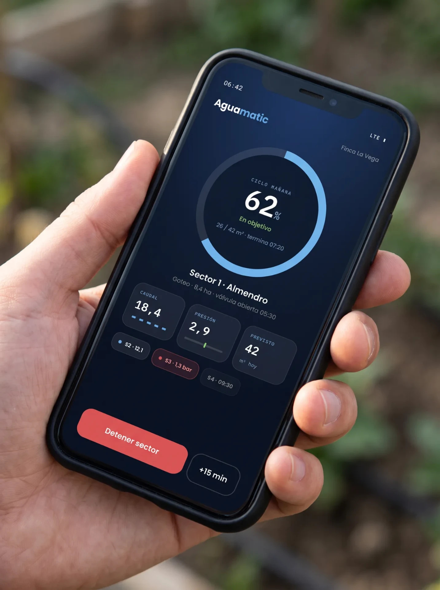 Mano sosteniendo un móvil con la app de Aguamatic en pantalla